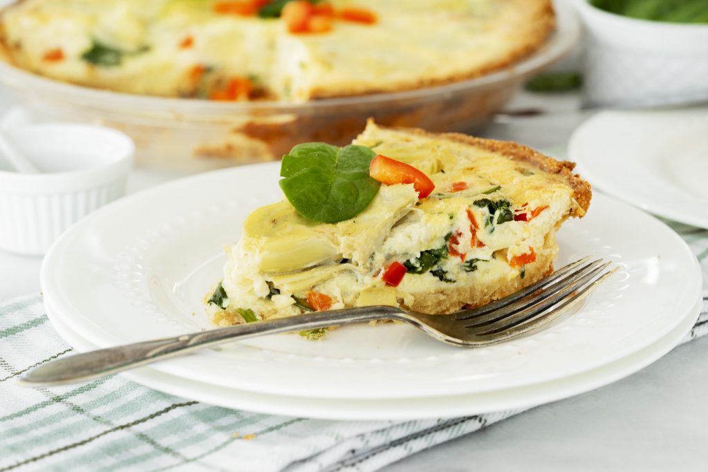 Slice of Baked Artichoke Quiche on a Plate